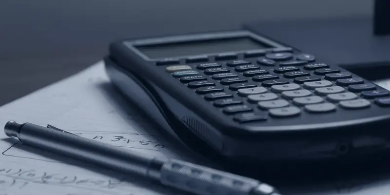 A calculator and a pen resting on handwritten notes